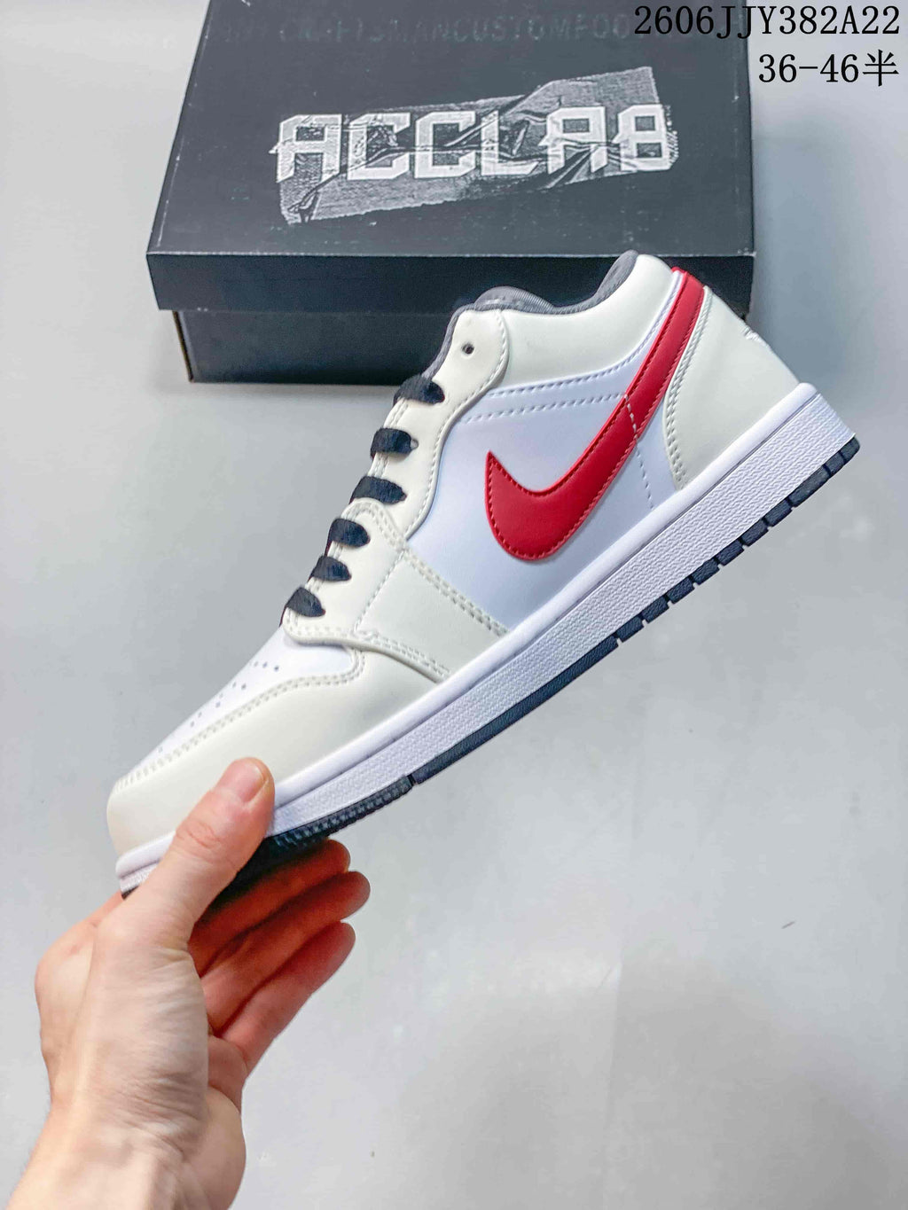 Side profile of a white low-top sneaker with red side accent and grey outsole detail