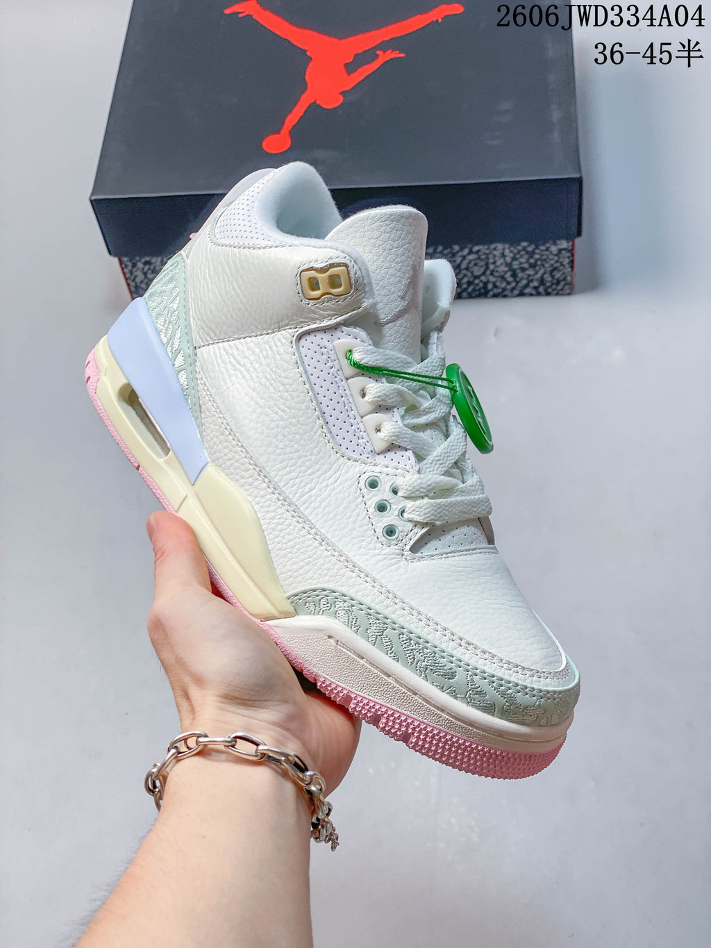 Angled front and side view of the white sneaker with pale mint patterned overlays