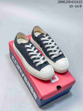 Pair of navy Converse All Star low-top sneakers with white laces and toe caps, shown on a Converse box