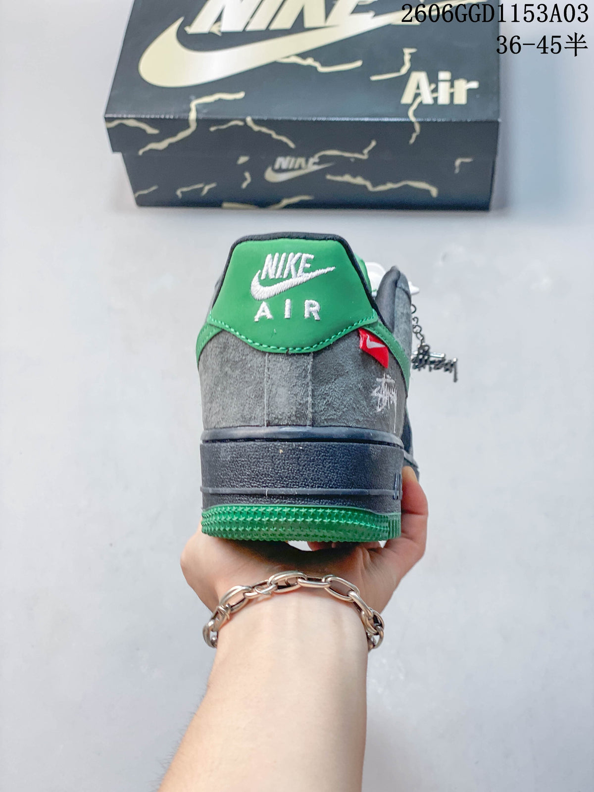 Rear view of the Nike Air Force 1 sneakers with green heel accents