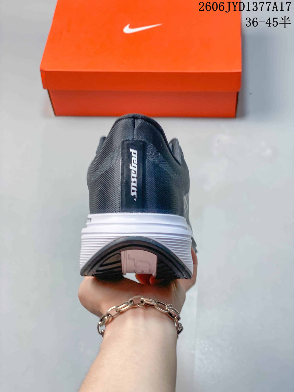 Rear view of the charcoal sneaker showing its heel and layered white sole