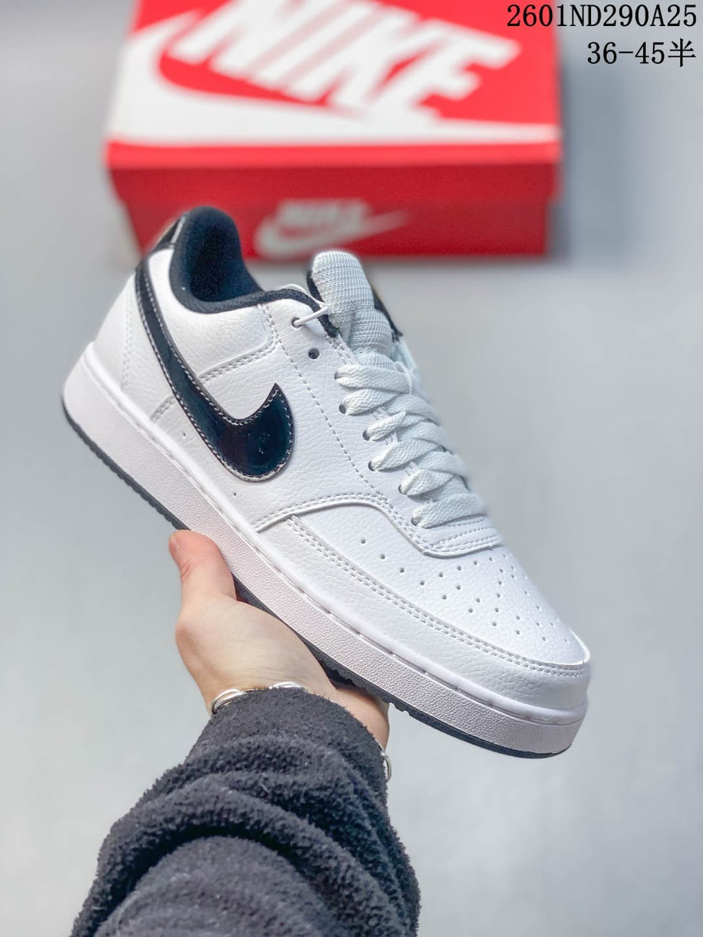 White Nike Court Vision Low-style sneaker with dark navy accents and perforated toe