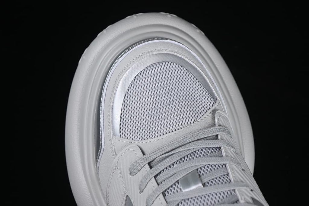 Top view of the sneaker toe, mesh-look panel, and laces
