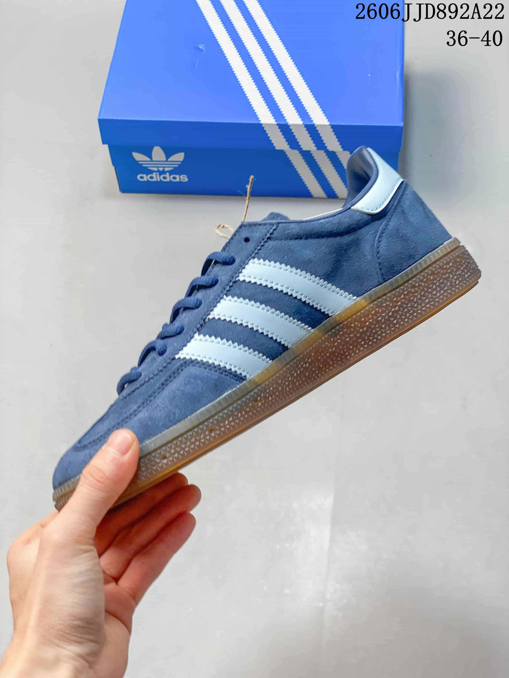 Side profile of a blue adidas sneaker with light-colored stripes and a gum-colored sole