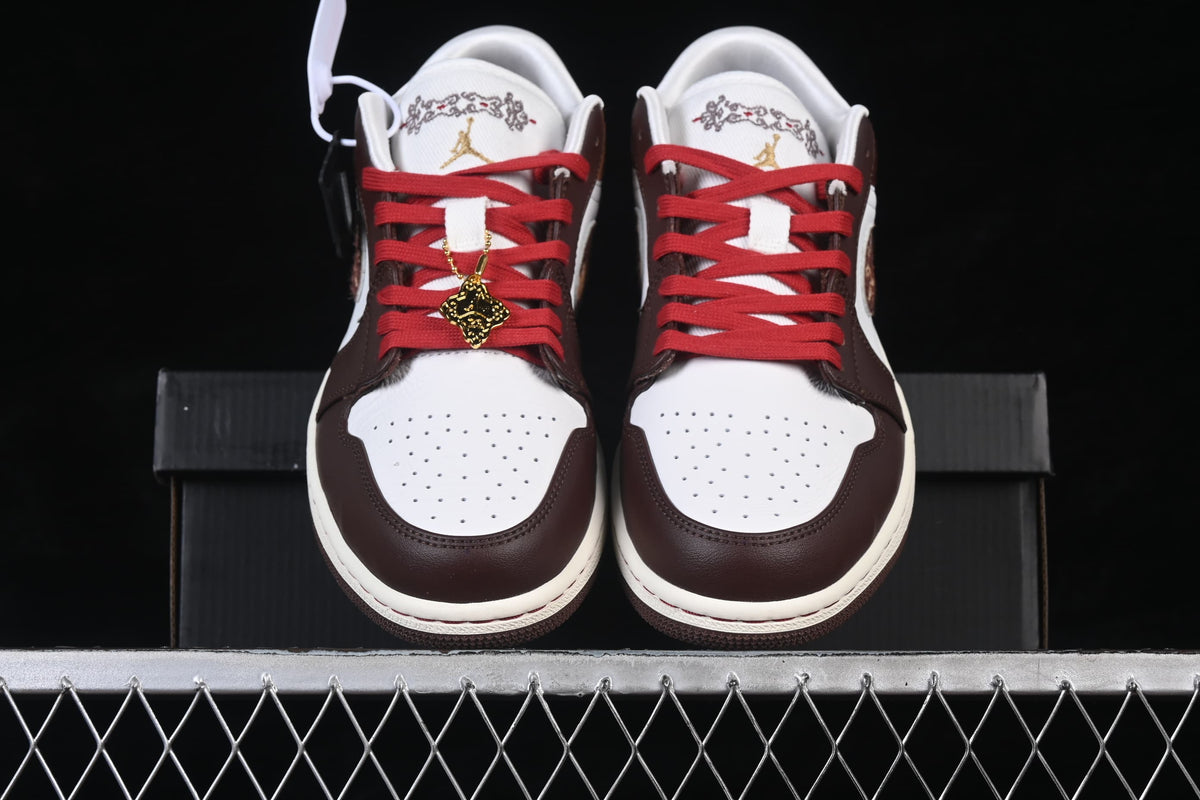 Front view of the pair with red laces, white toe boxes, and embroidered tongue details.