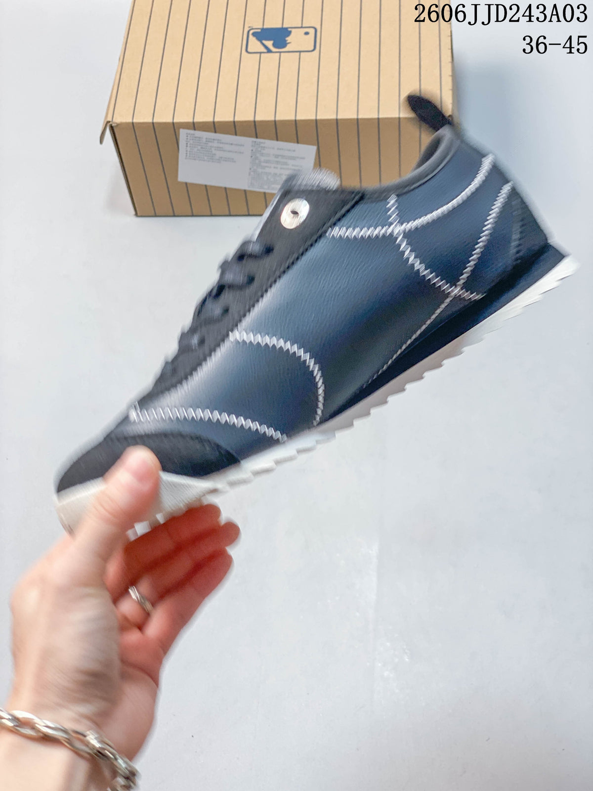 Side view of a navy New York Yankees sneaker showing contrast stitching and low-top design