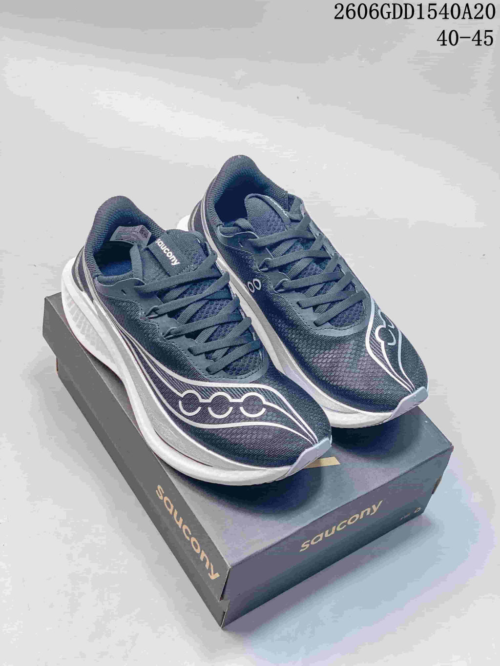 Pair of dark navy Saucony running shoes with white midsoles on a branded box.