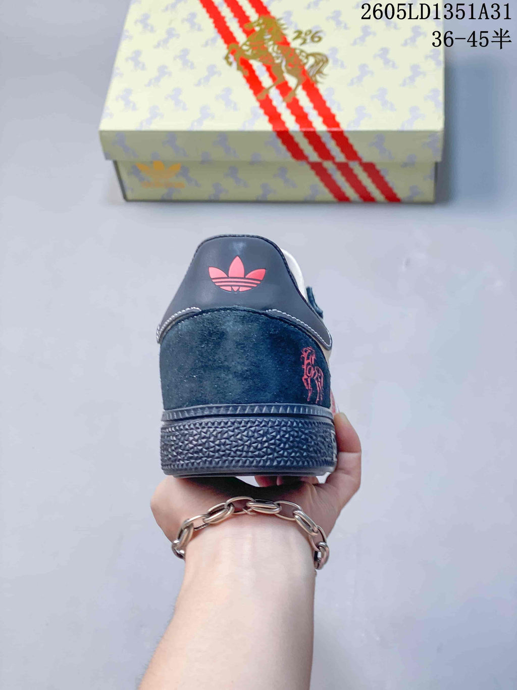Rear view of the sneaker showing the navy heel, red horse motif, and textured sole