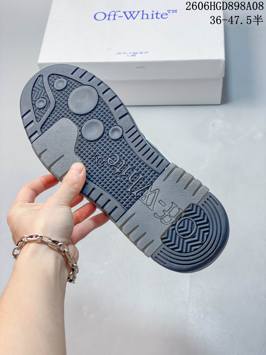 Close-up of the patterned gray outsole and sneaker box