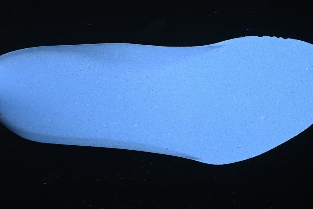 Blue boot-shaped footbed or insert shown against a dark background.