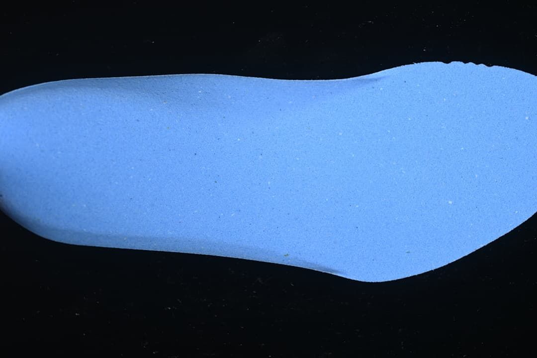 Blue boot-shaped footbed or insert shown against a dark background.