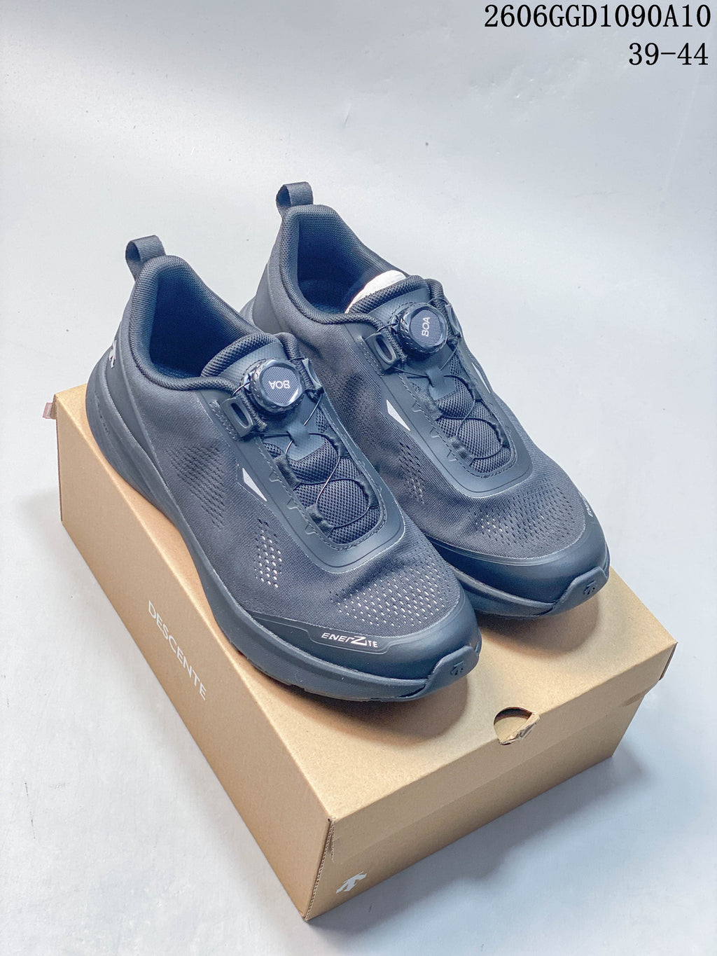 Pair of dark gray Descente Ease Air JR BOA sneakers showing the dial closure and perforated upper; image text lists sizes 39–44.