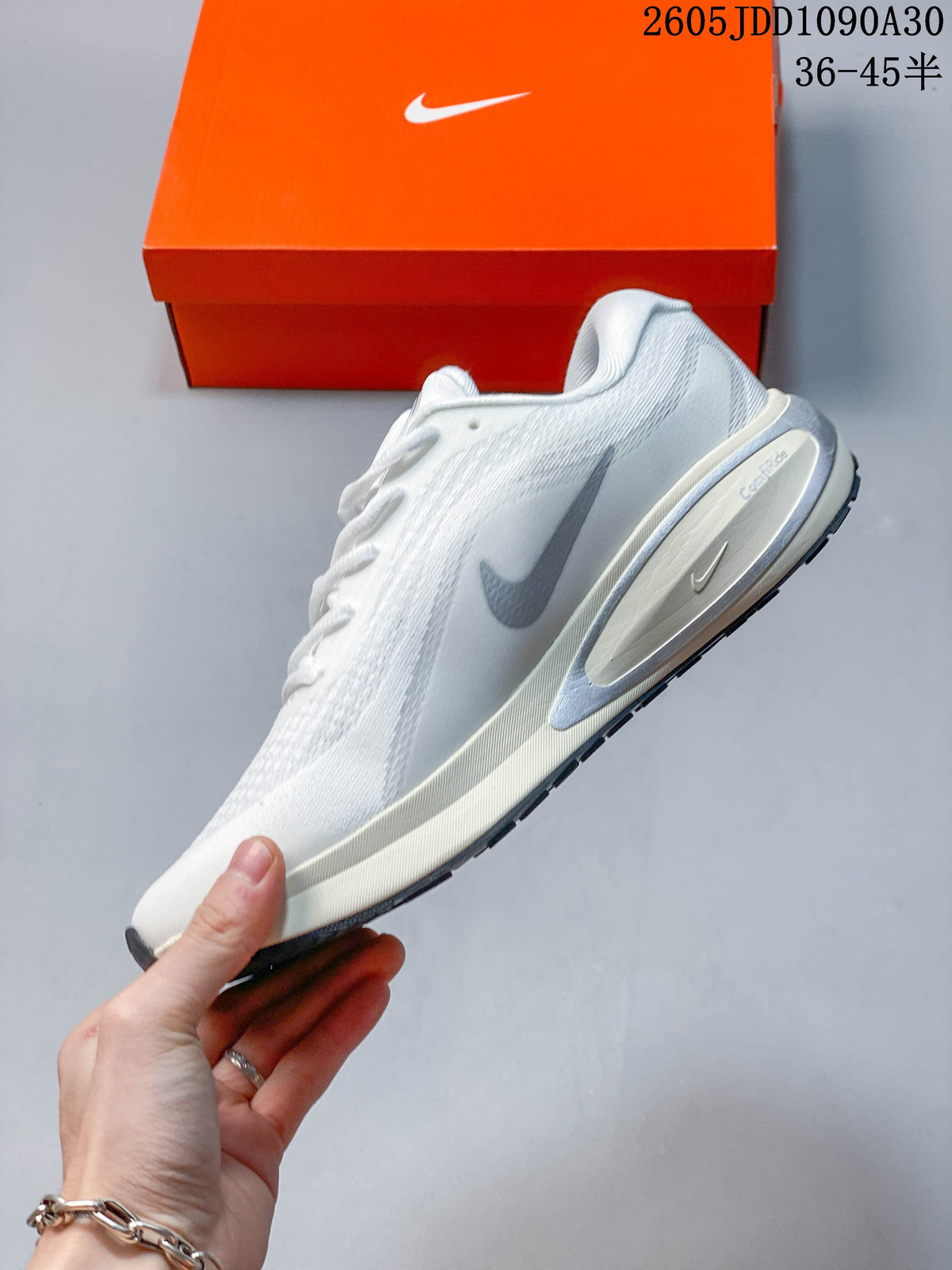 Side profile of a white Nike Journey Run shoe with gray Swoosh and midsole details.