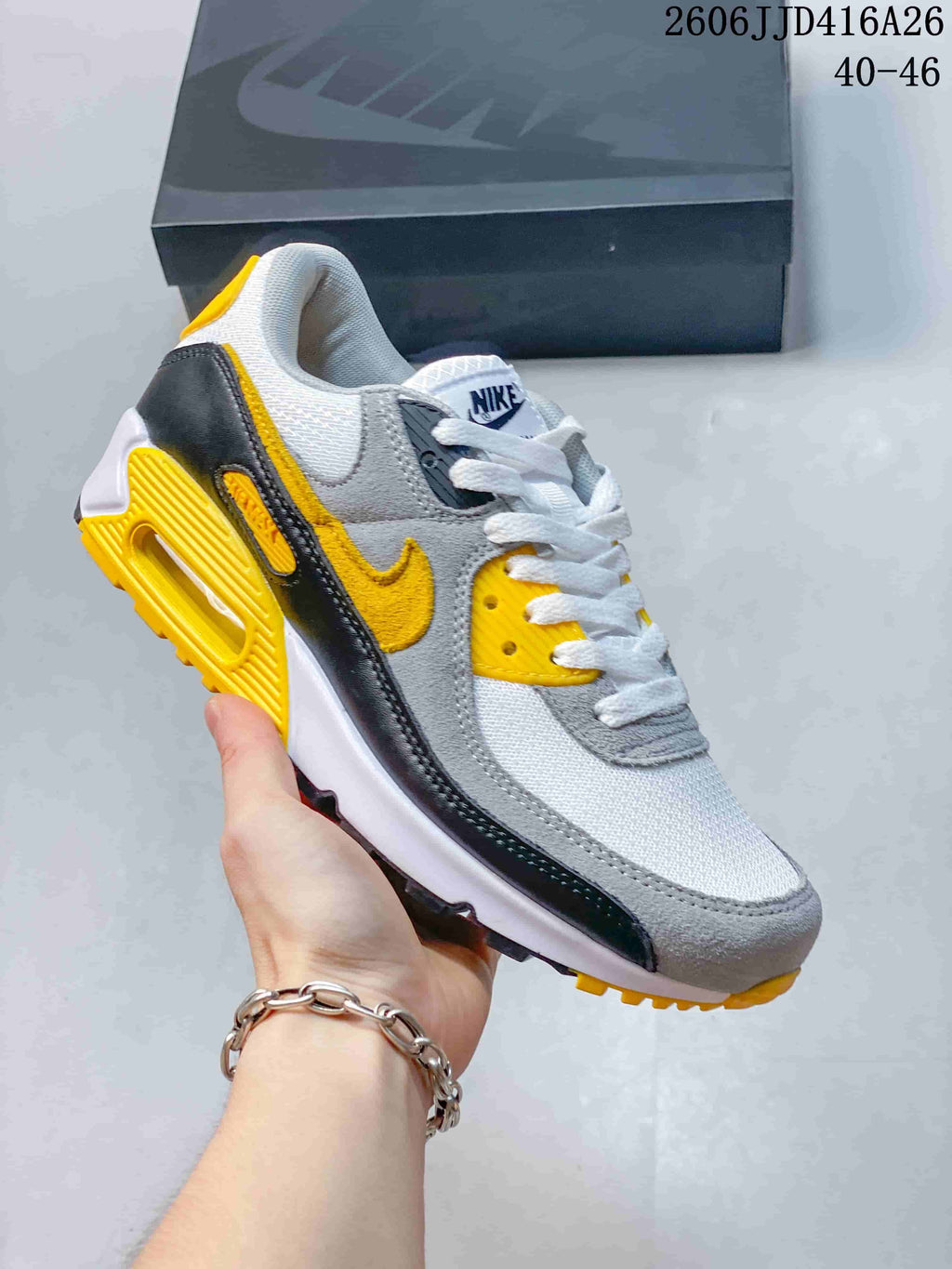 Gray, white, black, and yellow Nike Air Max 90 sneaker.