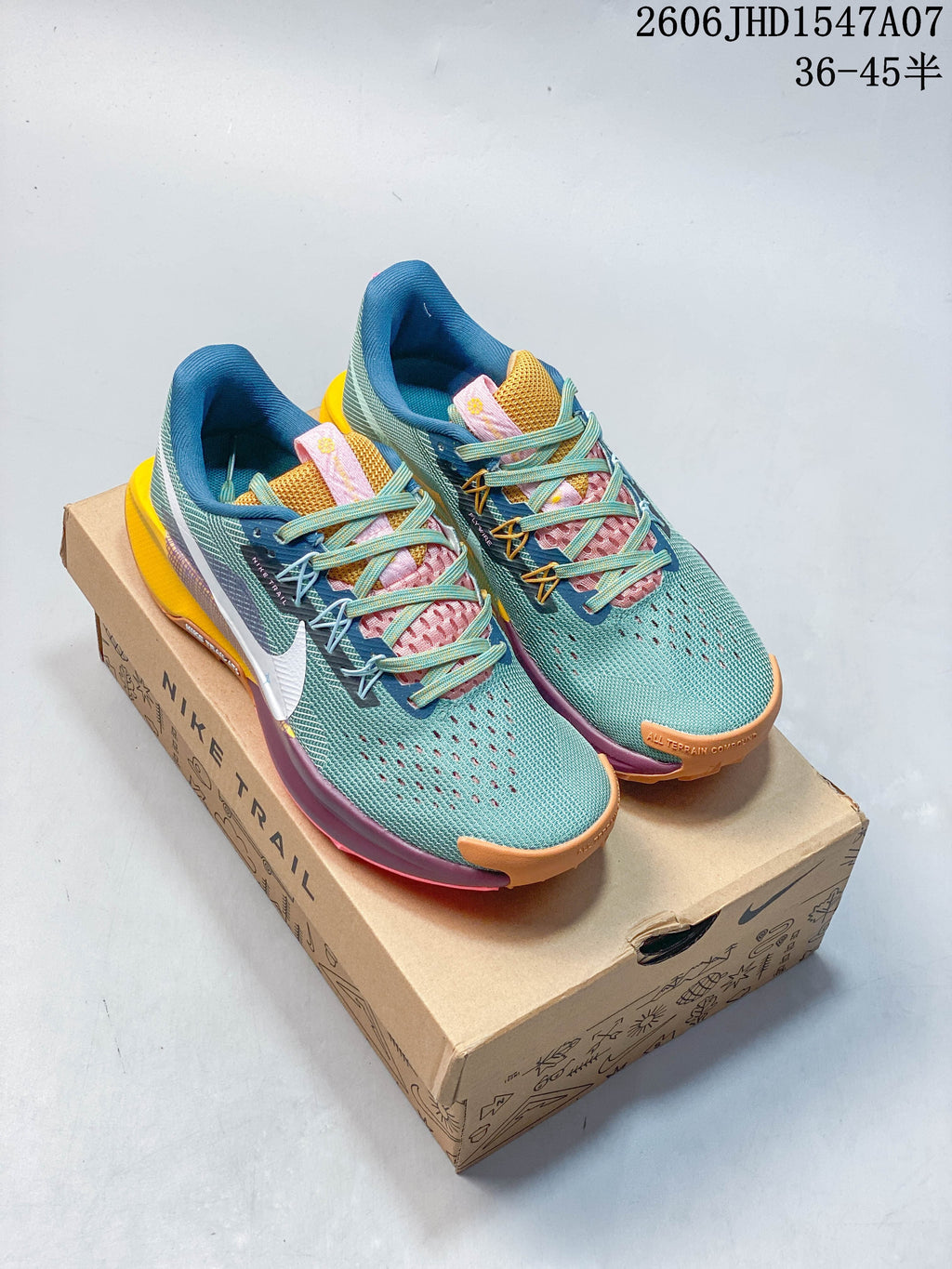 Pair of teal Nike ReactX Pegasus Trail 5 shoes on a Nike Trail box, shown from above.