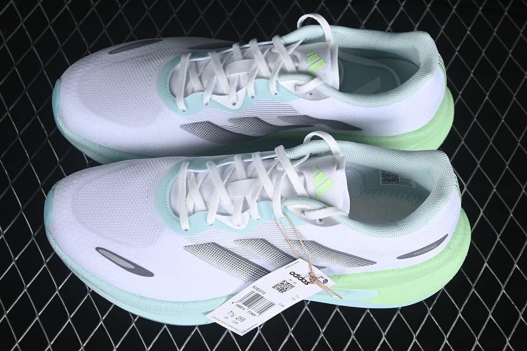 Pair of white Velostar KI6015 sneakers with silver stripes and mint and lime accents