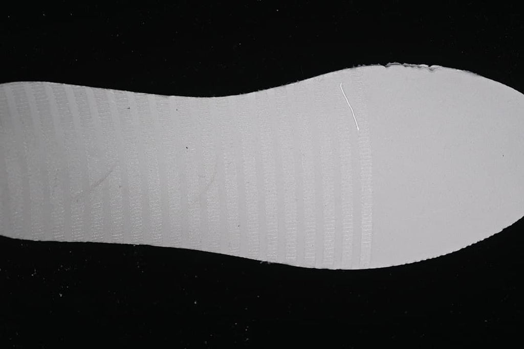 Close-up of the shoe outsole showing its white surface and tread.