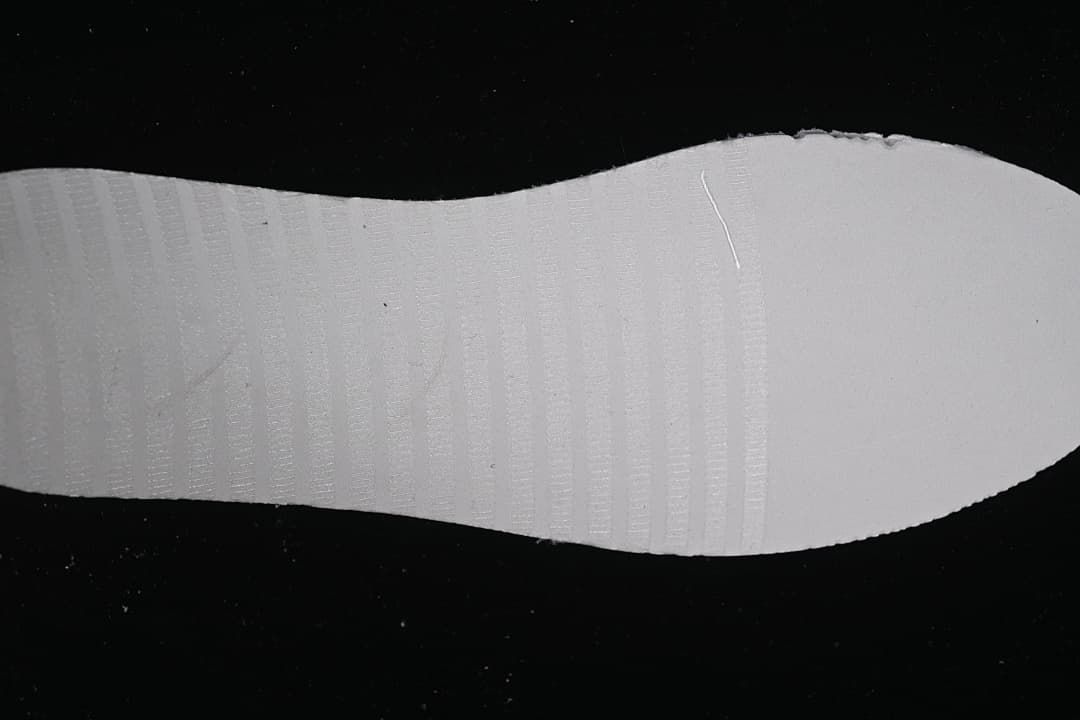 Close-up of the shoe outsole showing its white surface and tread.