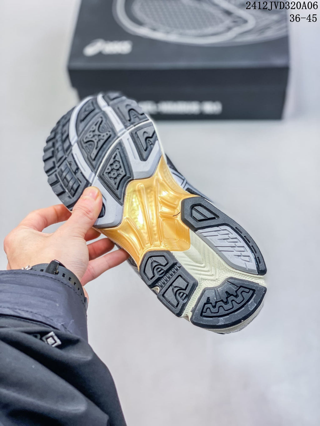 Underside of a sneaker showing a segmented black, gray, cream, and amber outsole.