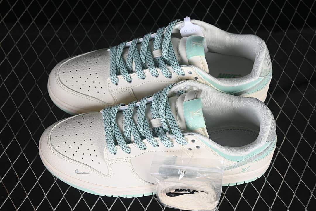 Top view of a pair of off-white and mint-green low-top sneakers with blue-green laces and spare white laces.