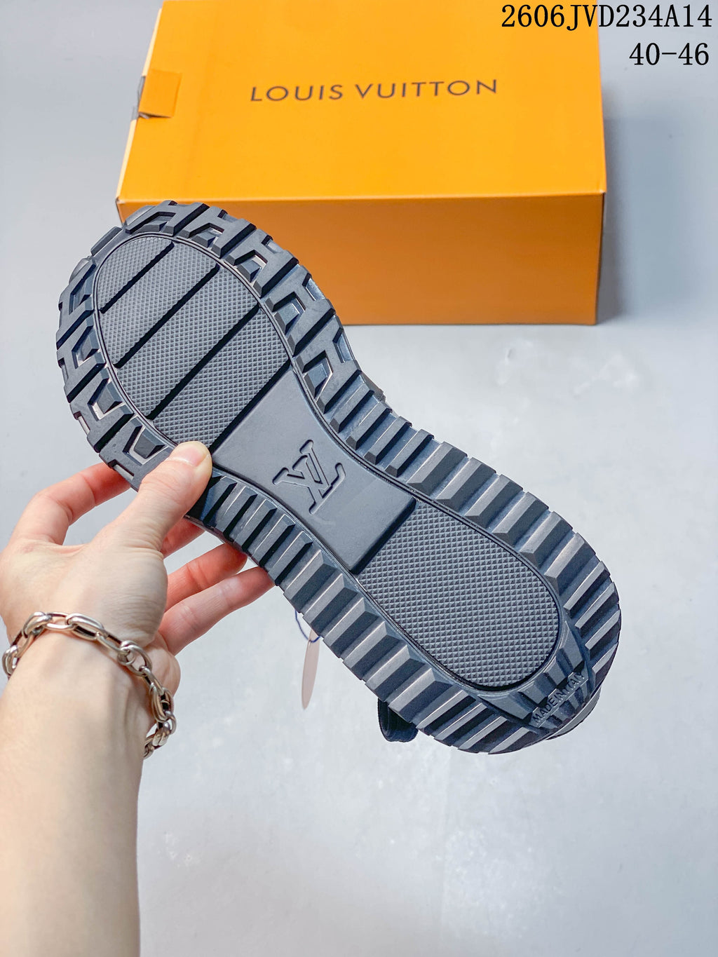 Close-up of the gray sneaker outsole showing its textured tread and molded center detail