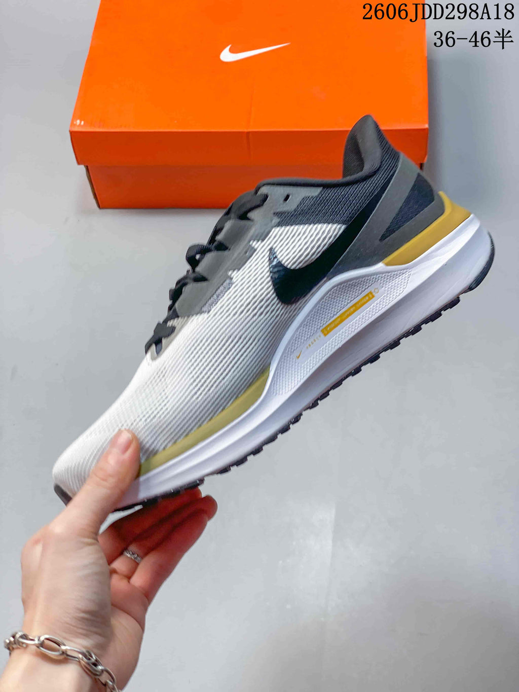 Side profile of the shoe with a white textured upper, dark overlays and yellow accents.
