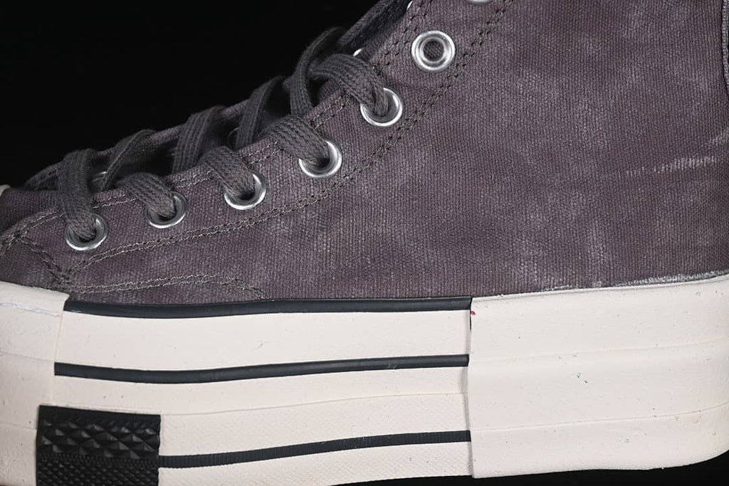 Close-up of the gray upper, laces, eyelets, and striped platform sole.