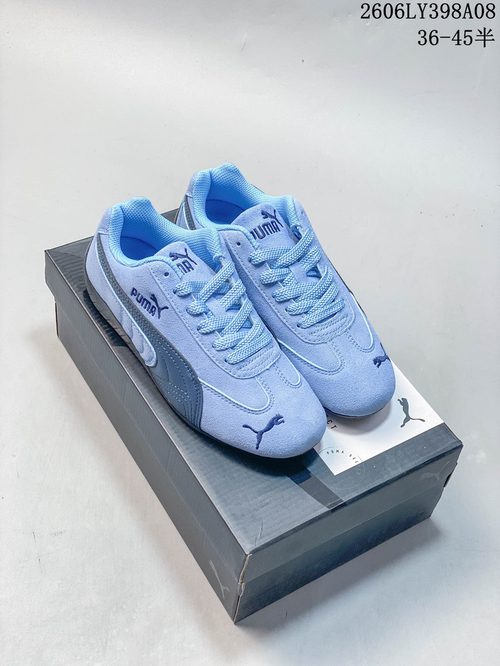 Light blue PUMA Speedcat OG sneakers with dark side stripes on a box