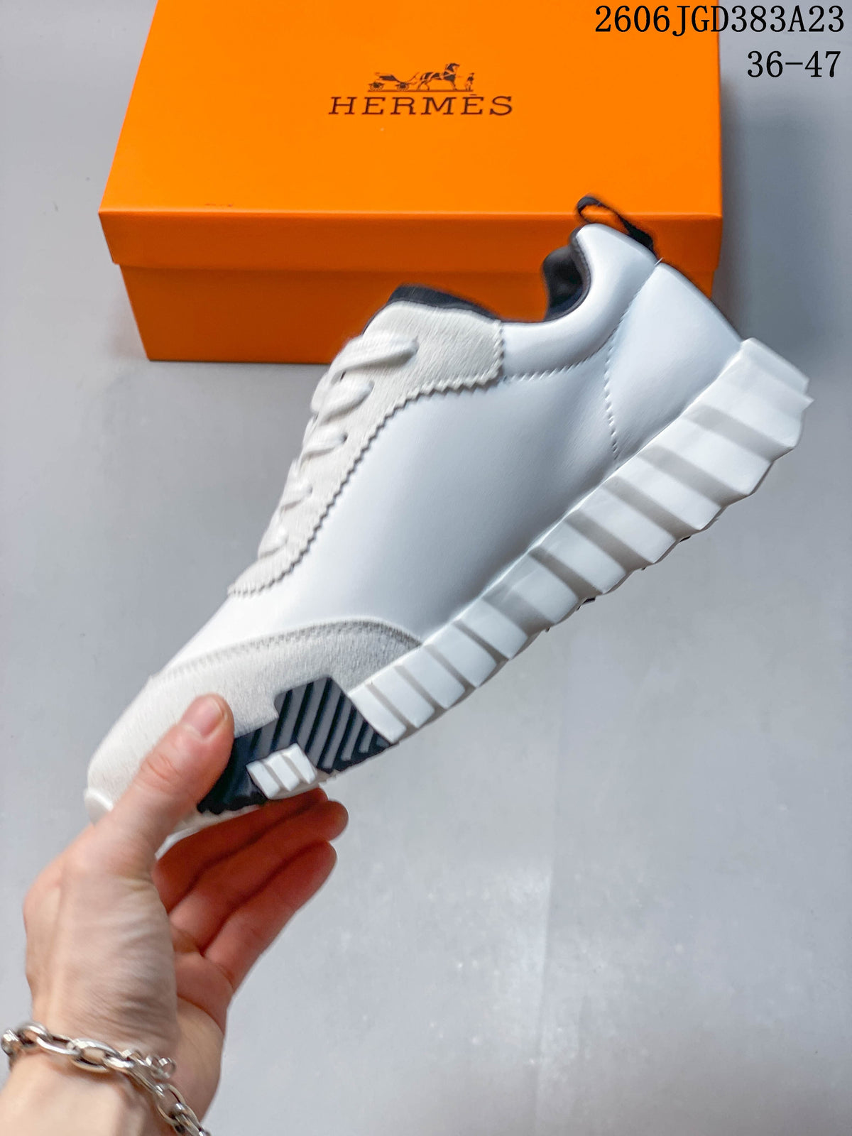 Side view of a white sneaker with suede-textured panels and a ridged outsole