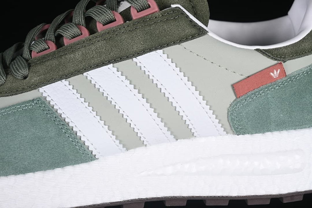 Close-up of white side stripes, green overlays, and the white midsole