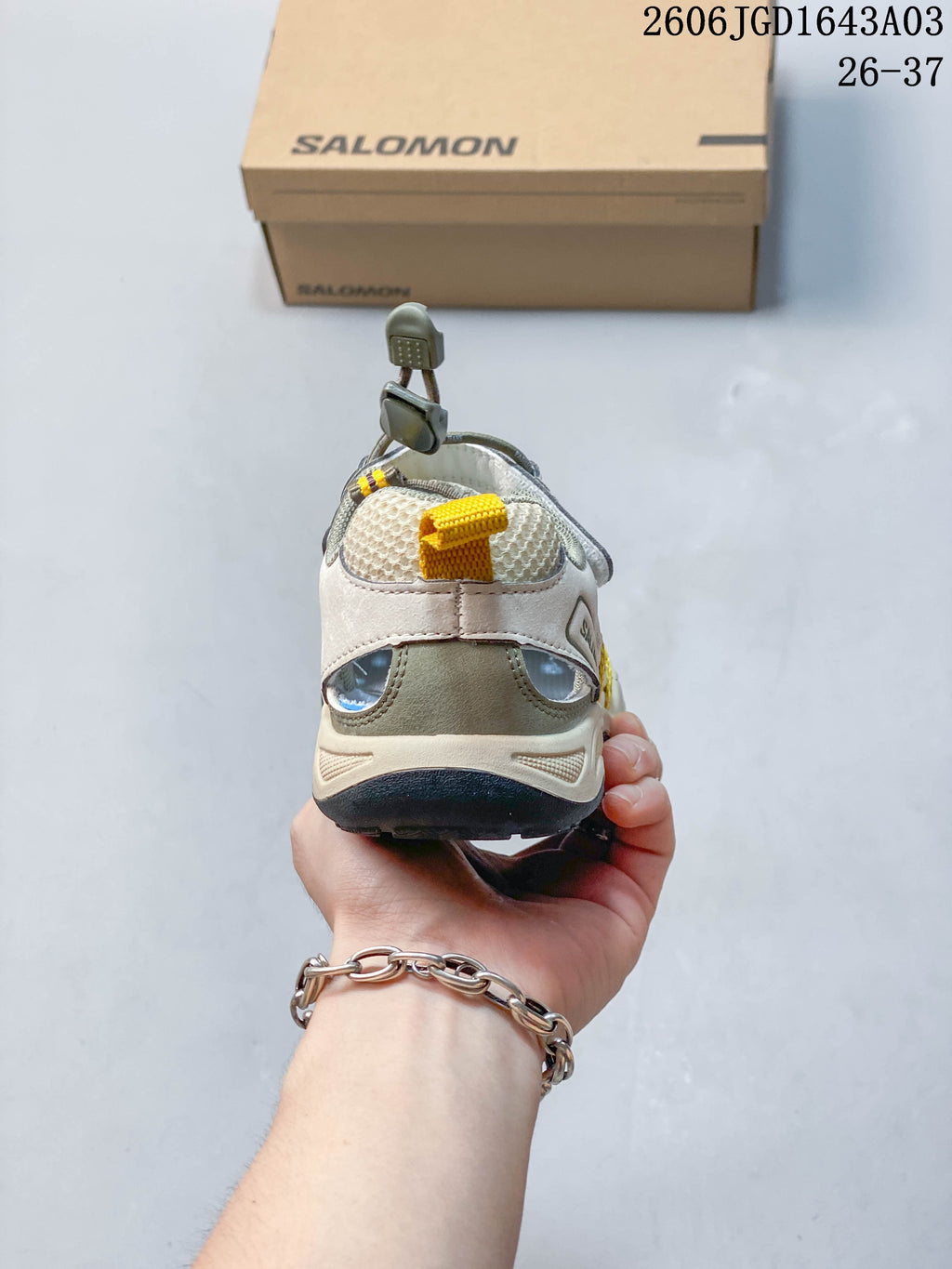 Rear view of a beige and gray Salomon kids sneaker