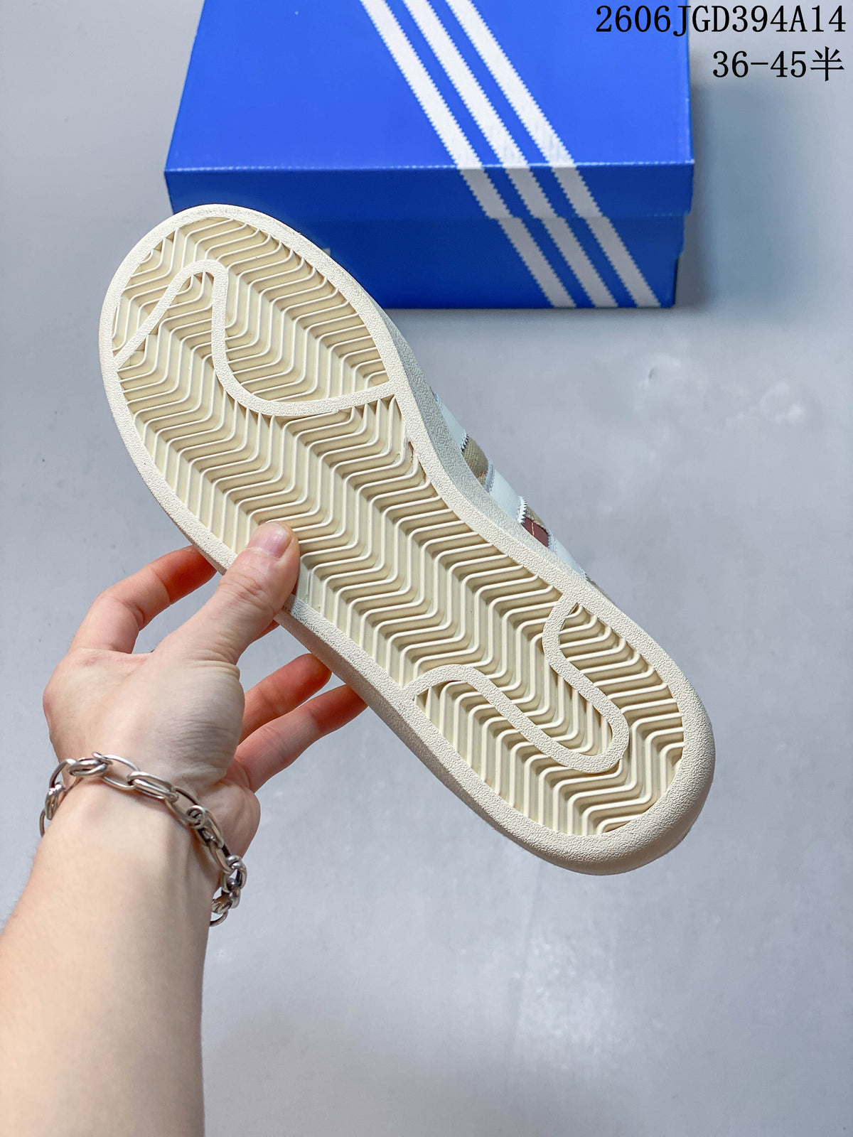 Close-up of the patterned outsole on a beige and white Superstar sneaker