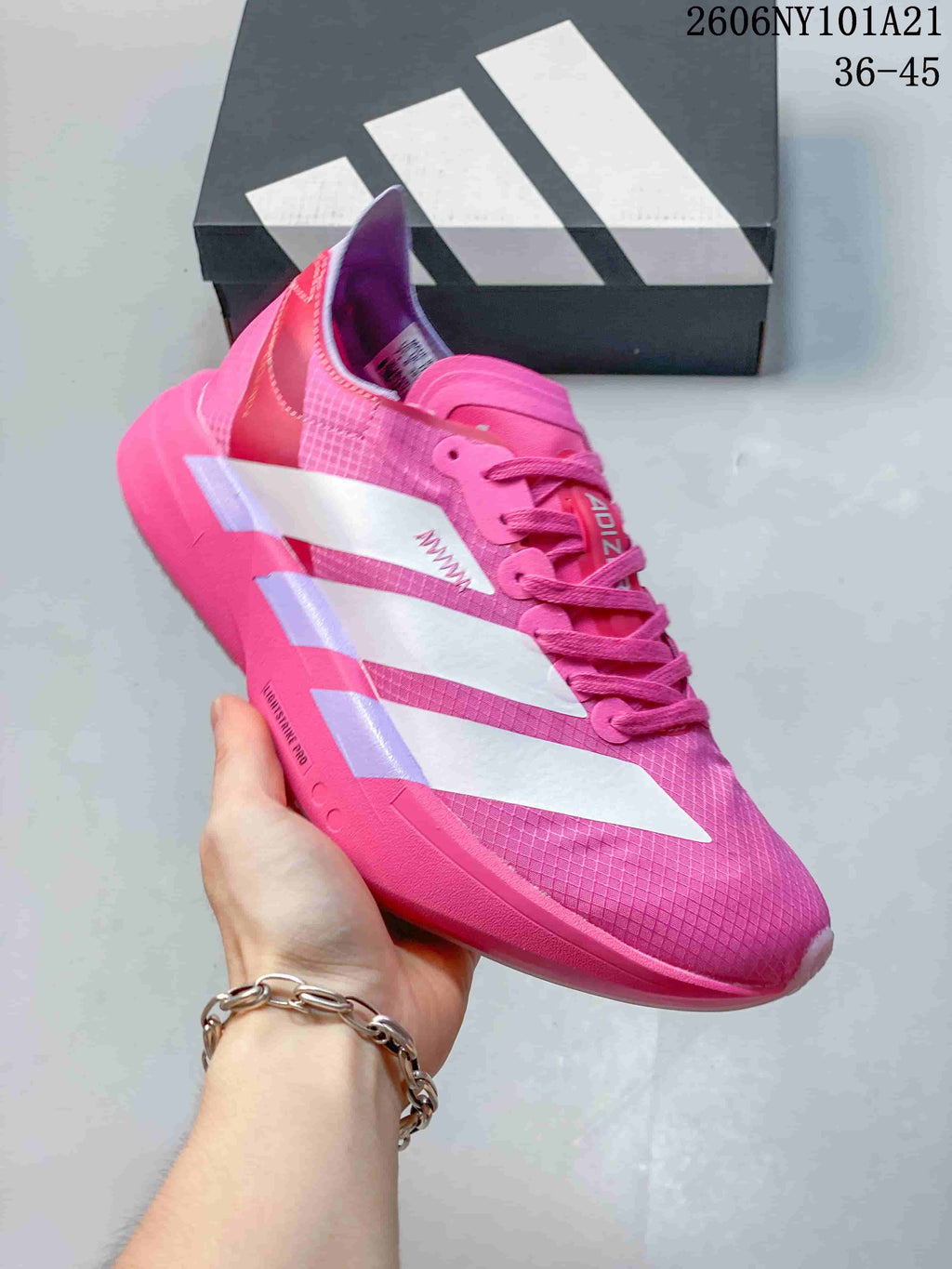 Side view of the pink shoe with white stripes and patterned upper