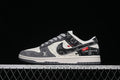 Side view of a gray, off-white, and black patterned low-top sneaker with red accents.