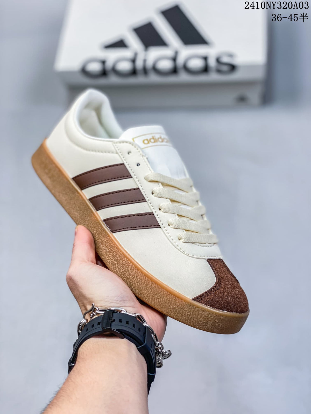 Angled side view of the cream sneaker with brown accents