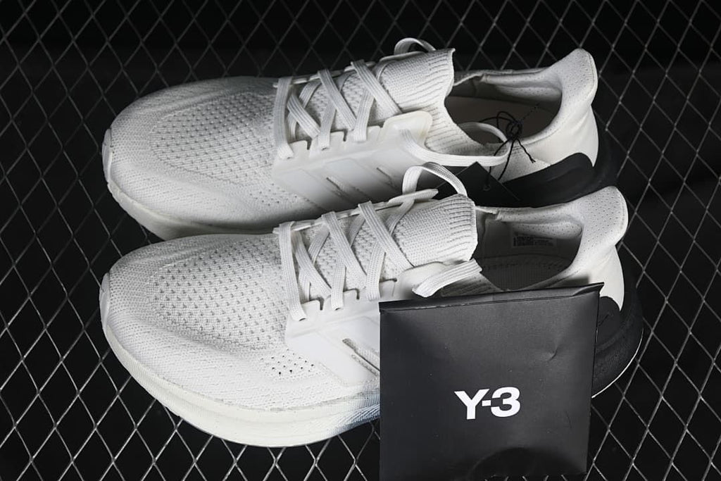 Pair of white and black Y-3 Ultraboost 5 shoes with a Y-3 box