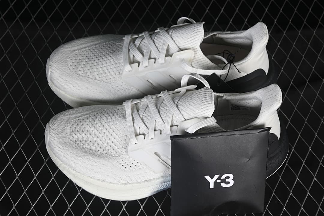 Pair of white and black Y-3 Ultraboost 5 shoes with a Y-3 box