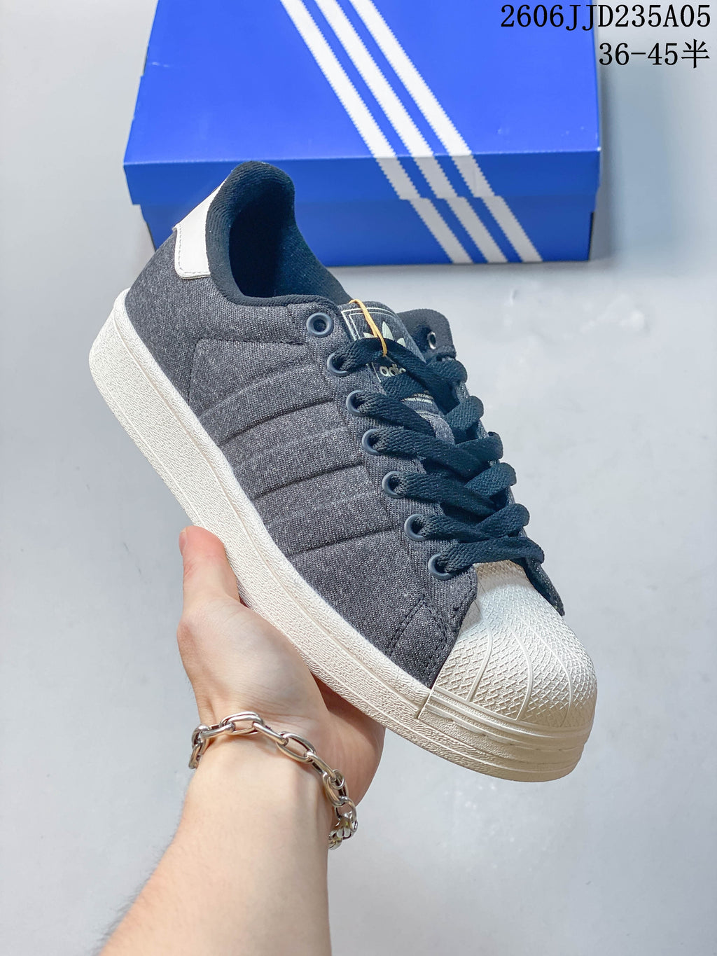 Angled view of a charcoal gray low-top sneaker with a white shell toe and outsole