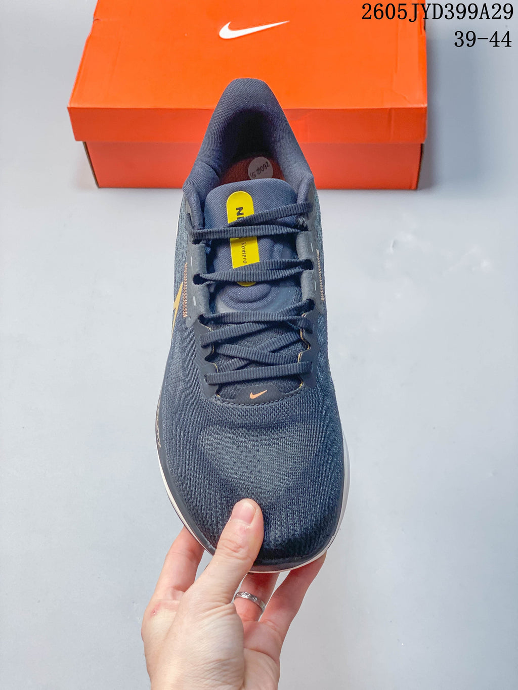 Top view of the lace-up upper and tongue of a dark gray Nike running shoe.