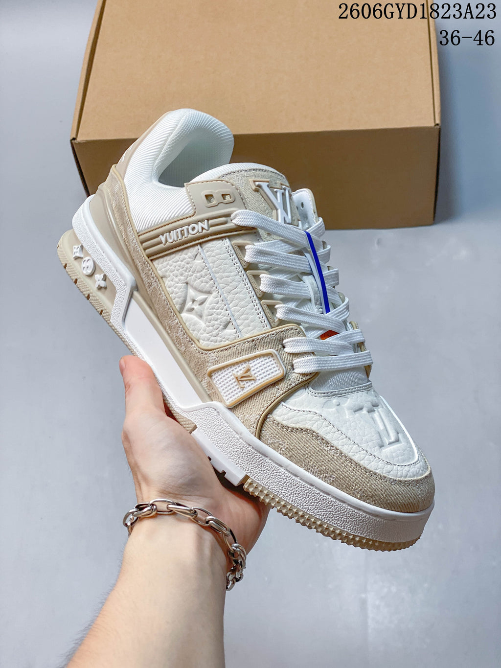 Angled side view of a white and beige Trainer Low sneaker