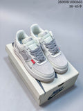Pair of white and gray low-top sneakers with gray laces and red accent tabs on a shoebox