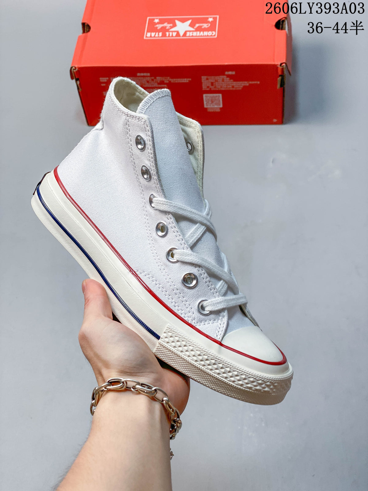 White high-top sneaker with metal eyelets and contrast sole trim