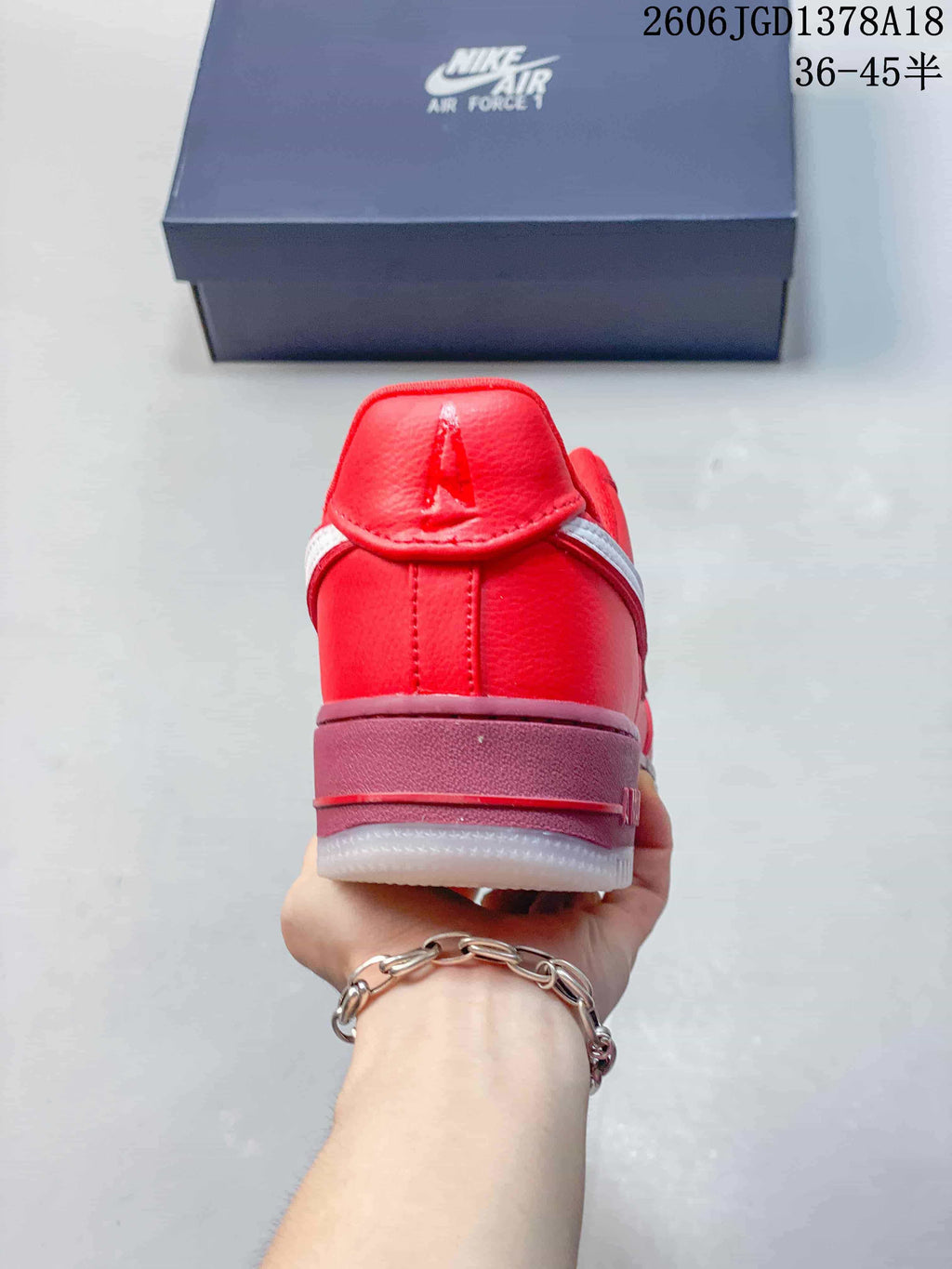 Rear view of a red low-top sneaker with a mauve-pink midsole and white outsole