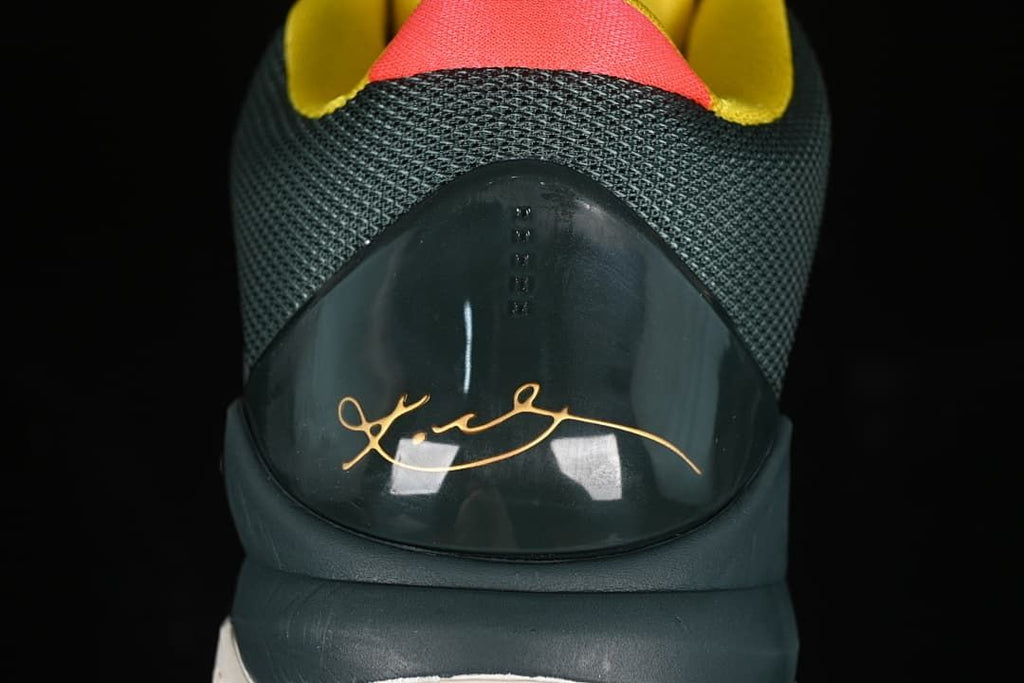 Rear view showing the textured heel, signature detail, and coral and yellow accents