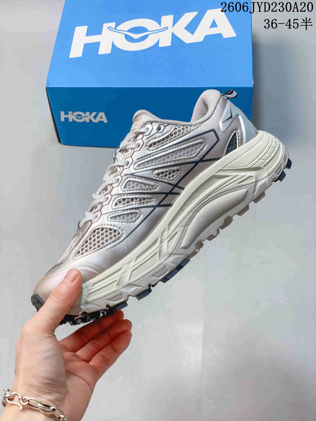 Side view of a silver-toned running shoe with mesh panels and a thick sole