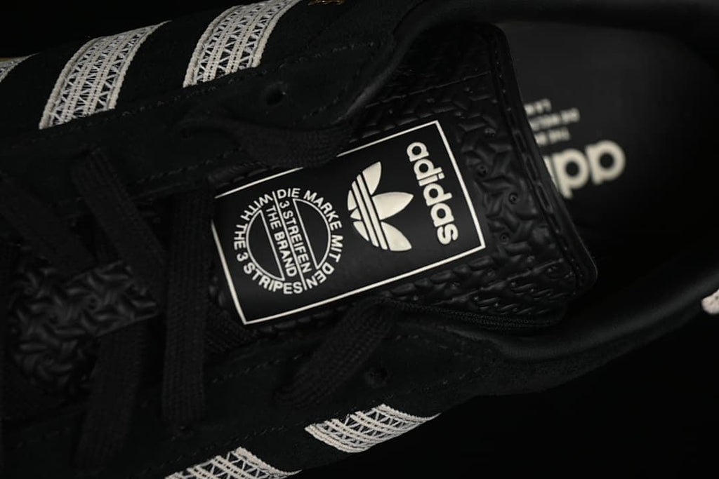 Close-up of the sneaker tongue label and black laces.