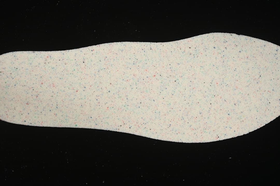 Close view of a light-colored insole with multicolor flecks.