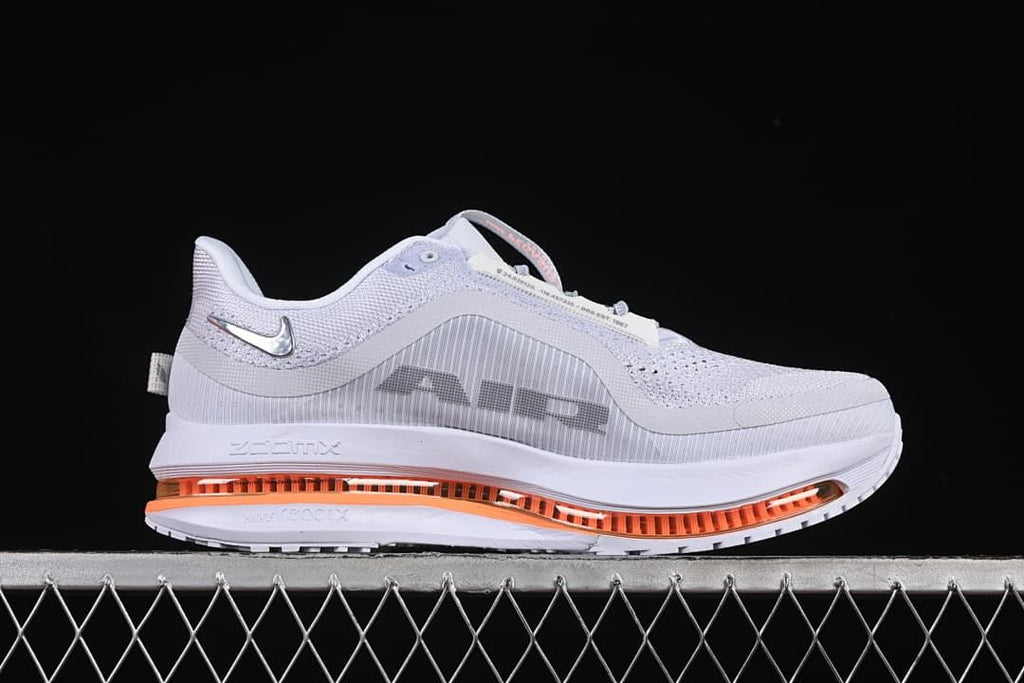 Side profile showing the gray upper, dark Swoosh, and orange sole detail