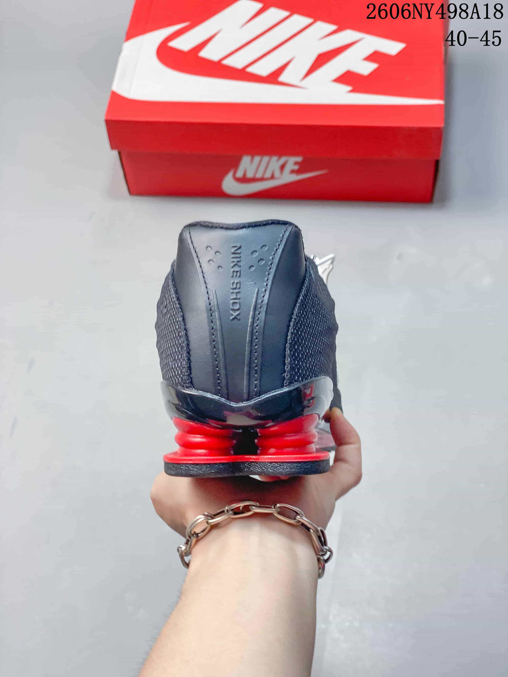 Rear view showing the red heel columns on a charcoal Nike Shox TL sneaker.