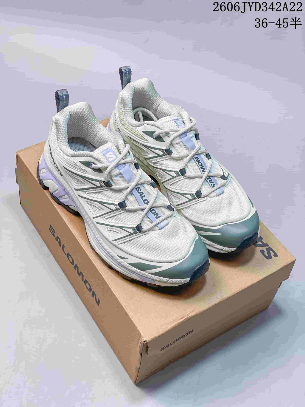 Pair of light-colored Salomon XT-6 Expanse Seasonal sneakers with green and lavender accents, shown on a shoe box